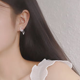 Asymmetrische Ohrringe mit blauem Kristall